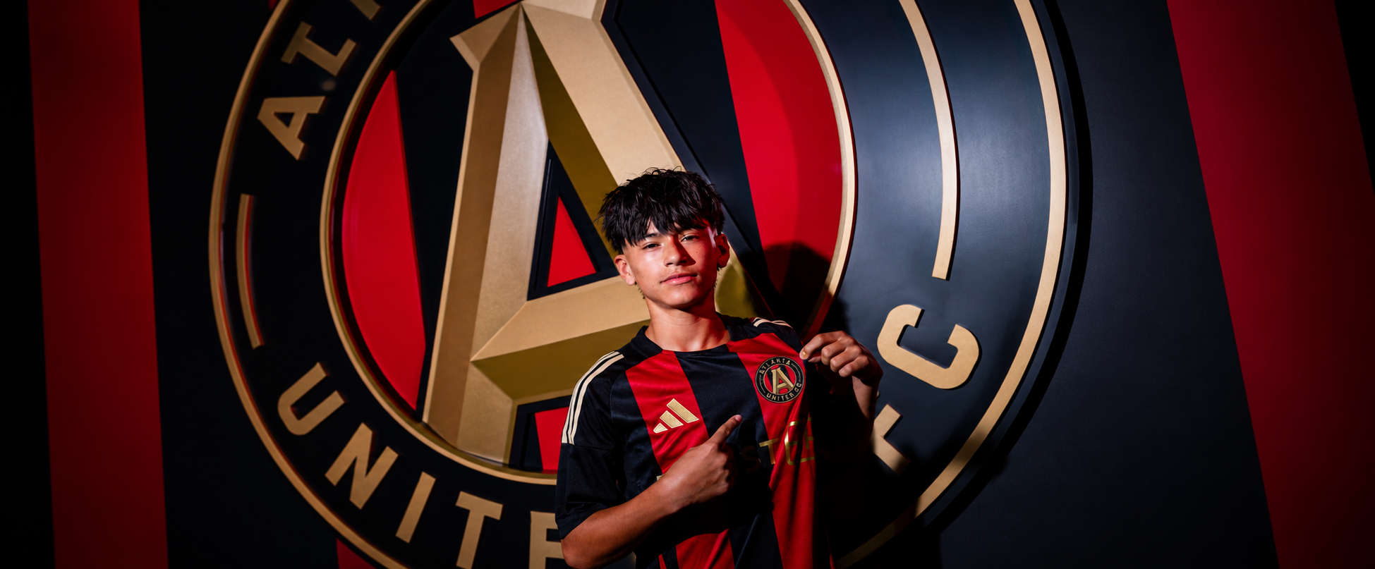 Player in an Atlanta United kit in front of the club crest