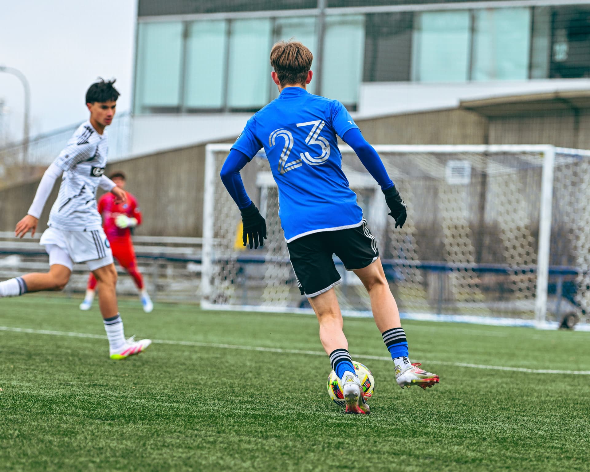 Midfielder in blue driving forward with the ball