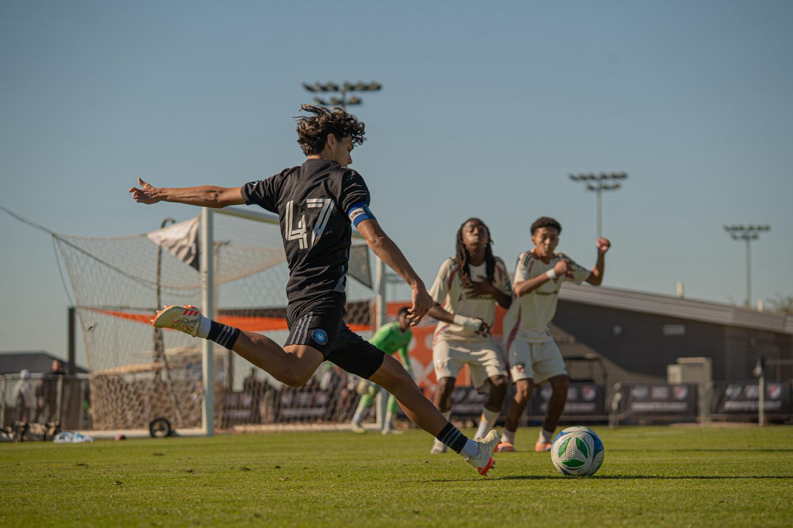 OPSM player striking the ball at an MLS NEXT match