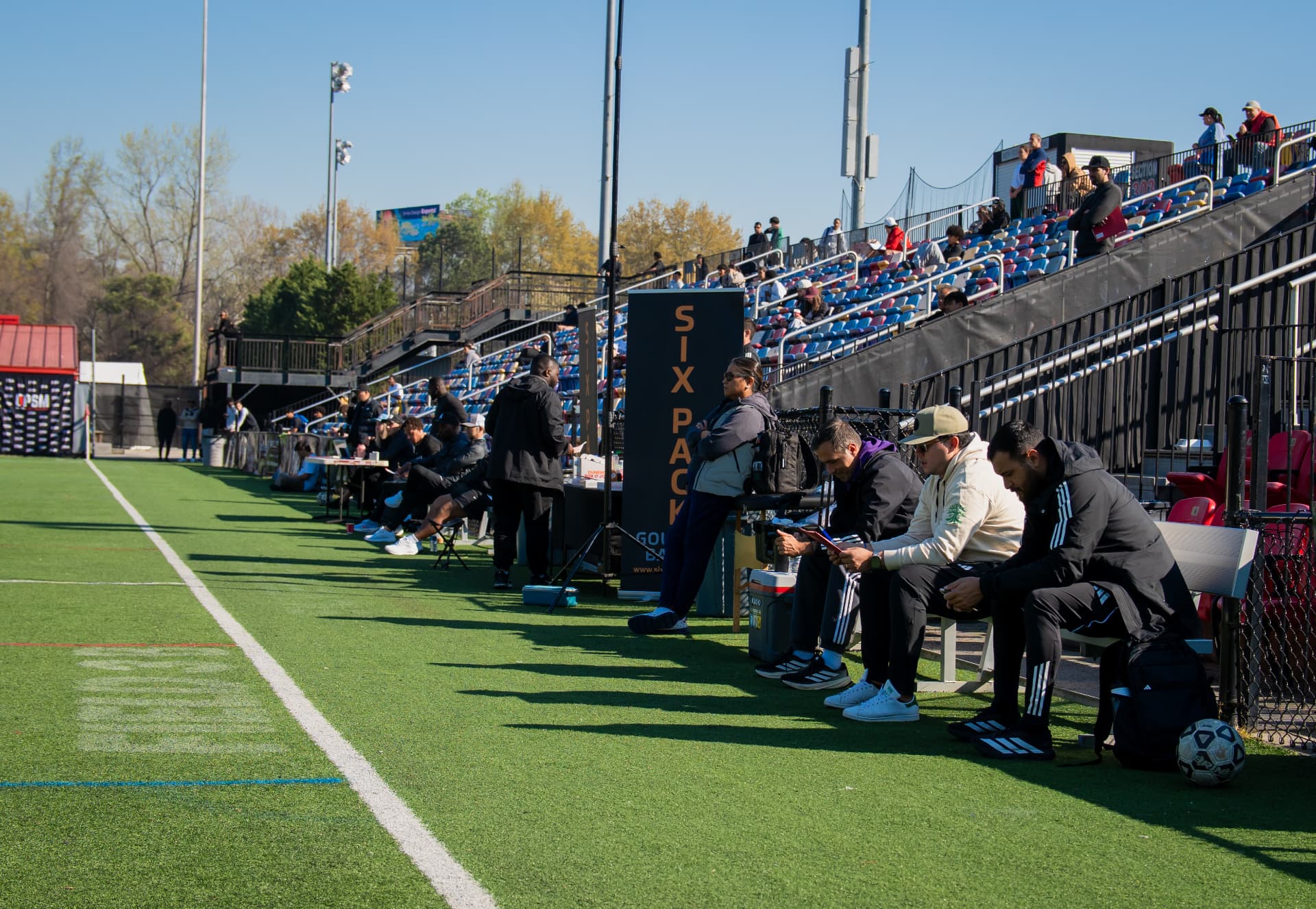 Scouts and coaches lining the sideline at an OPSM event
